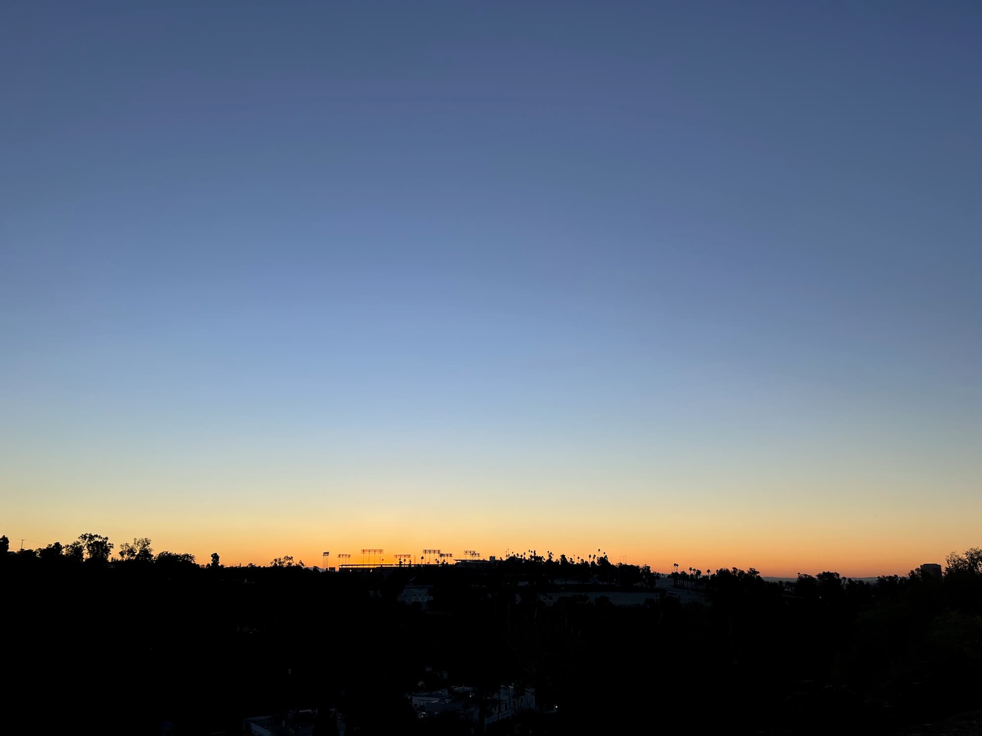 Sun rises over Dodger Stadium and Elysian Park in Los Angeles