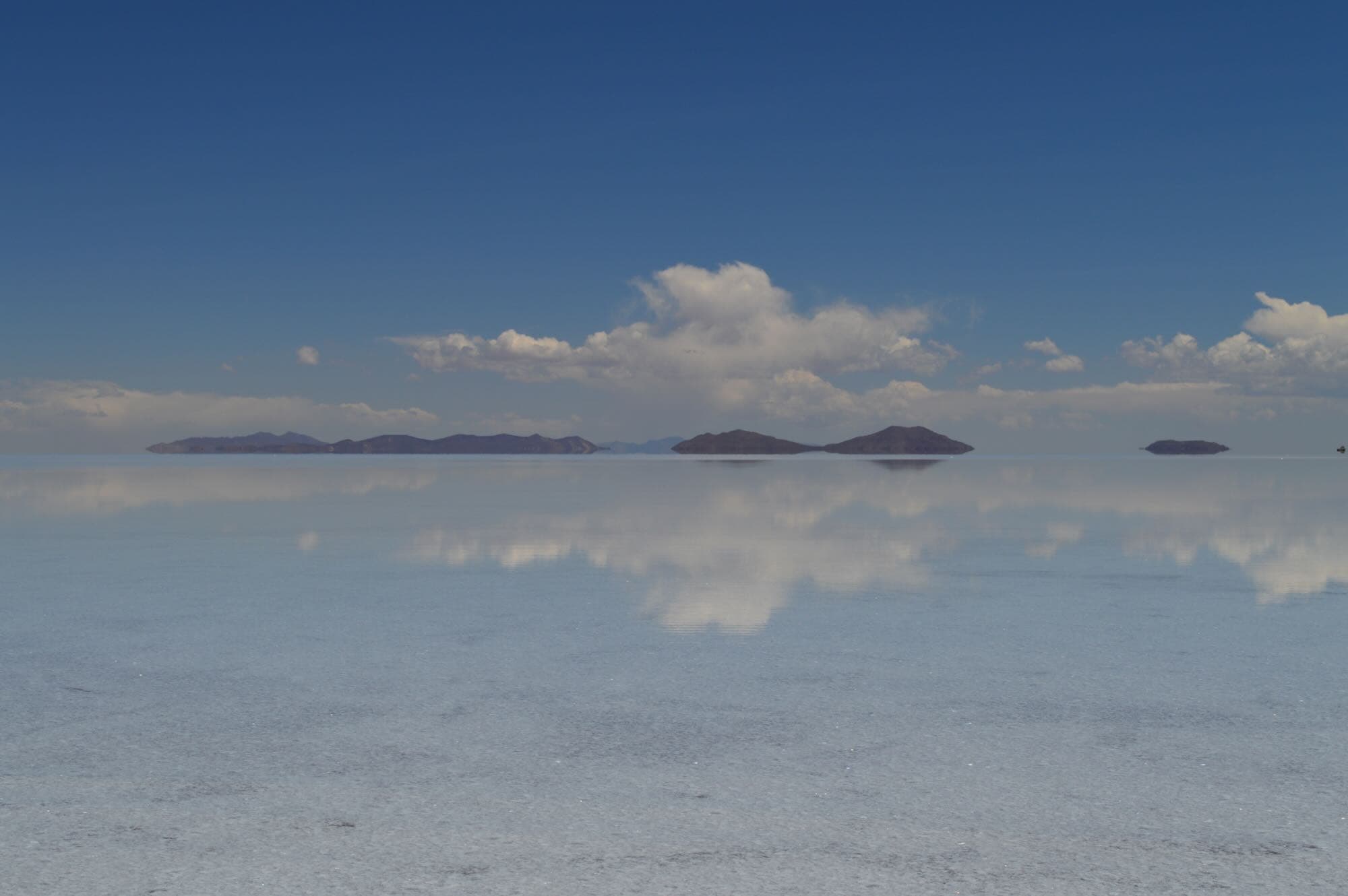 Hero image - Thin layer of water creates a glass mirror effect over the expansive Uyuni salt flats, Bolivia