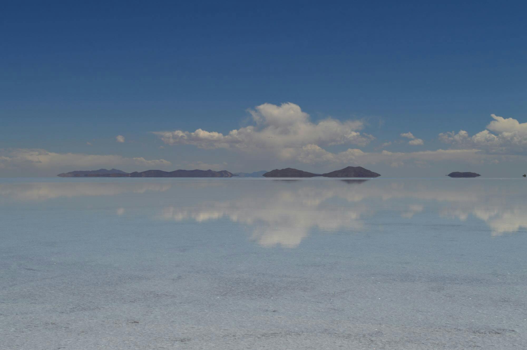 Hero image - Thin layer of water creates a glass mirror effect over the expansive Uyuni salt flats, Bolivia